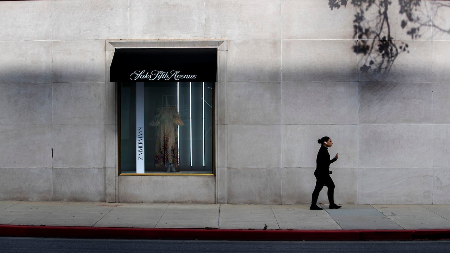 Woman walking past Saks Fifth Avenue building